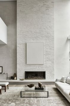 a living room with white furniture and a fireplace