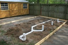 an unfinished backyard with pipes in the ground