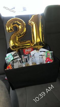 a car trunk filled with lots of items and gold foil number 23 balloon in the back