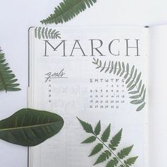 an open planner with green leaves on it