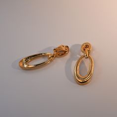 Featuring a subtle brushed 18ct gold plated finish, these statement earrings add a retro touch to any outfit. Featuring clip-on backs, no piercing required. As the GT Vintage range is vintage, each piece will be unique and may have minor imperfections. Extra care should be taken during wear and pieces should not come into contact with water, sweat, perfume and other substances that may damage its finish. Please note vintage jewellery is made from brass/copper/alloy metals and then plated with gold and therefore may contain nickel - those allergic to nickel should avoid allowing the jewellery making contact with the skin.  Delivered in a Gold Trip soft microfibre pouch within a presentation box, perfect for gifting yourself or others. To prevent your Gold Trip jewellery from breaking or tar Modern Gold Clip-on Earrings For Evening, Modern Gold-tone Clip-on Earrings For Formal Events, Gold-tone Drop Clip-on Earrings, Oval Metal Clip-on Jewelry, Classic Oval Clip-on Earrings, Elegant Oval Gold Clip-on Earrings, Clip-on Oval Earrings For Evening, Oval Metal Clip-on Earrings, Gold Oval Clip-on Earrings For Formal Occasions