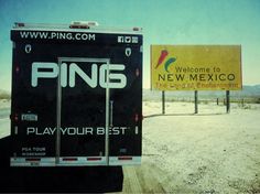 a truck parked on the side of a road next to a sign