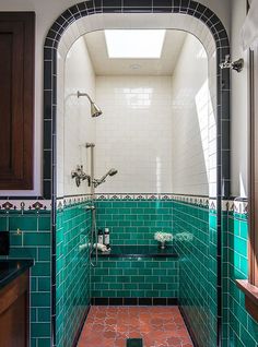 a bath room with a sink and a shower head mounted to the side of a wall