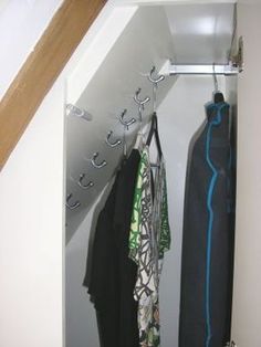 an open closet with clothes hanging from hooks