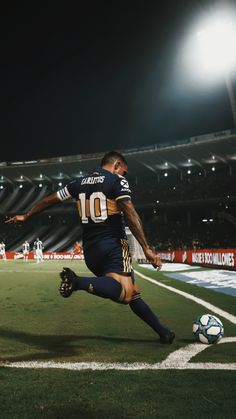 a man kicking a soccer ball on top of a field