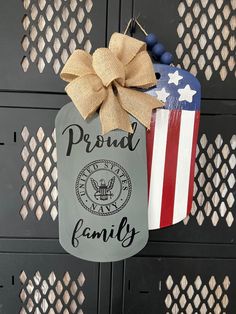 an american flag hanging from the side of a metal door with a proud family tag on it