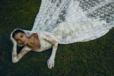 a woman laying on the ground in a white dress