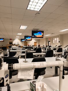 an empty classroom filled with desks and monitors