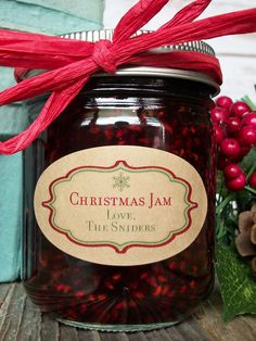 a jar filled with jam sitting on top of a wooden table next to christmas decorations