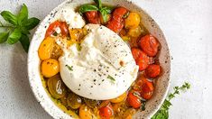 a white bowl filled with lots of different types of food on top of a table