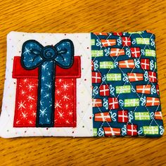 two pieces of fabric with bows on them sitting on top of a wooden table next to each other