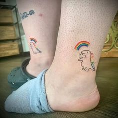 two people with tattoos on their legs and one has a rainbow in the shape of a horse