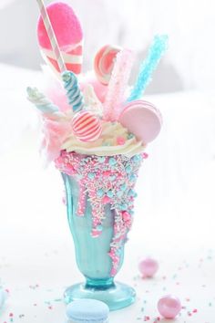 an ice cream sundae with candy and candies in it on a white table