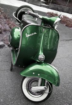 a green scooter is parked on the street