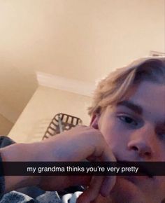 a young man is holding his hand up to his face and the words, my grandma thinks you're very pretty