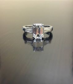 an emerald cut diamond ring with baguettes on the side