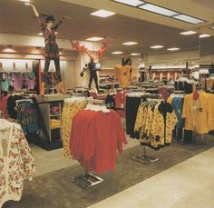 an open store with clothes on racks and mannequins