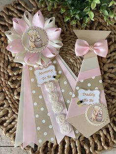 three pink and brown baby shower ties on a wicker basket next to a potted plant