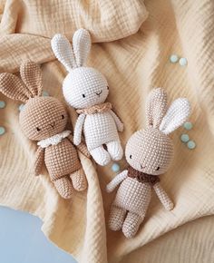 three crocheted stuffed animals sitting on top of a blanket