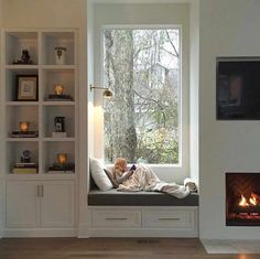 a living room filled with furniture and a fire place next to a large open window