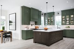 a large kitchen with green cabinets and white counter tops