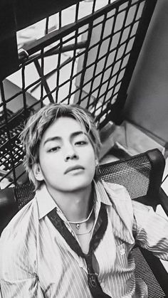 black and white photograph of a young man sitting in front of a shopping cart with his eyes closed