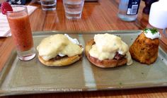 three burgers on a plate with sauce and potatoes