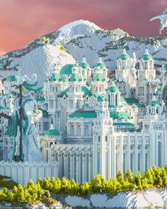 a large white building with green roofs and trees in front of a snowy mountain range