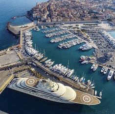 an aerial view of a large cruise ship docked at a harbor with many boats in the water