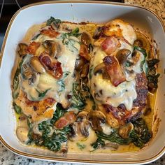 a casserole dish with chicken, mushrooms and spinach in a creamy sauce