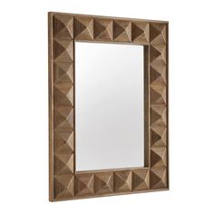 a mirror that is sitting on top of a wooden frame with an intricate design in the middle