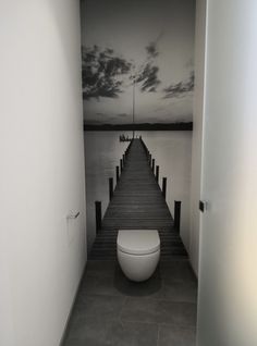 a white toilet sitting on top of a wooden pier