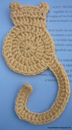 a crocheted cat tail and tail is shown on top of an open book