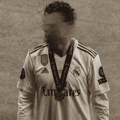 a soccer player with his face obscured by the camera's hair and medal around his neck