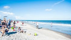 many people are on the beach and in the water