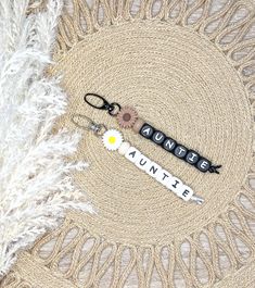 a pair of scissors sitting on top of a rug next to a white feather and some type of name tag