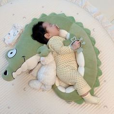 a baby sleeping next to a stuffed animal