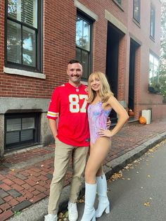 a man and woman posing in front of a brick building