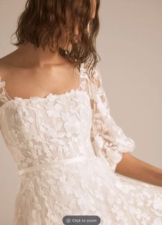 a woman wearing a white dress with flowers on it