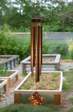 a wind chime hanging from the side of a garden