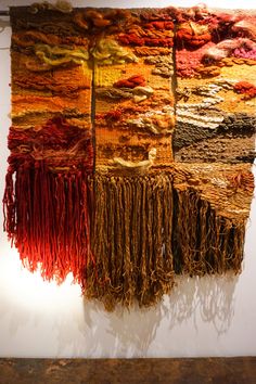 a wall hanging made out of different colored yarns