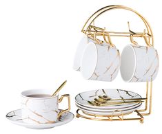 a set of four cups and saucers on a gold rack with marbled plates