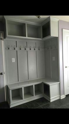 an empty room with several white lockers and two doors on the side of it