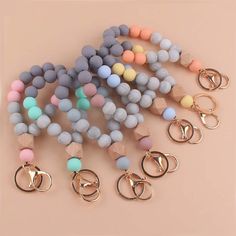 several different colored beads and rings on a pink background