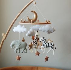 a baby crib mobile with animals and stars hanging from it's sides in a nursery room