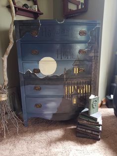 a blue dresser sitting on top of a carpeted floor next to a book shelf