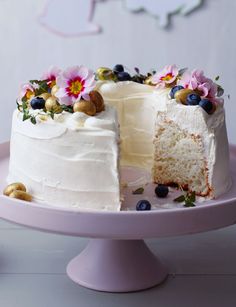 a white cake with blueberries and flowers on it