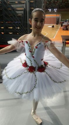 a young ballerina is posing for the camera