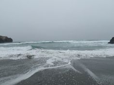 the water is choppy and foamy on the beach