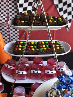 three tiered trays filled with brownies and candy covered cookies on top of each other